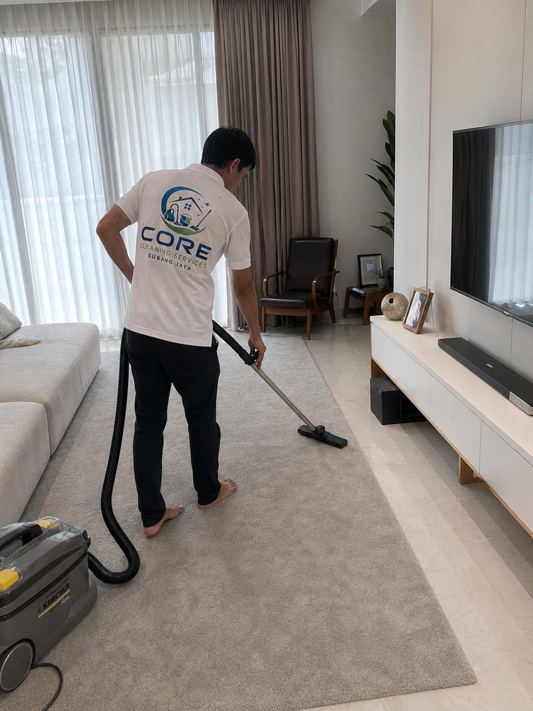 A Core Cleaning Services Subang Jaya specialist deep-cleaning a living room carpet in Subang Jaya